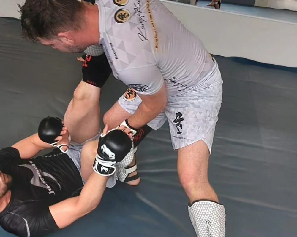 Vale-Tudo-Training: Kämpfer kontrolliert seinen Gegner am Boden mit MMA-Handschuhen